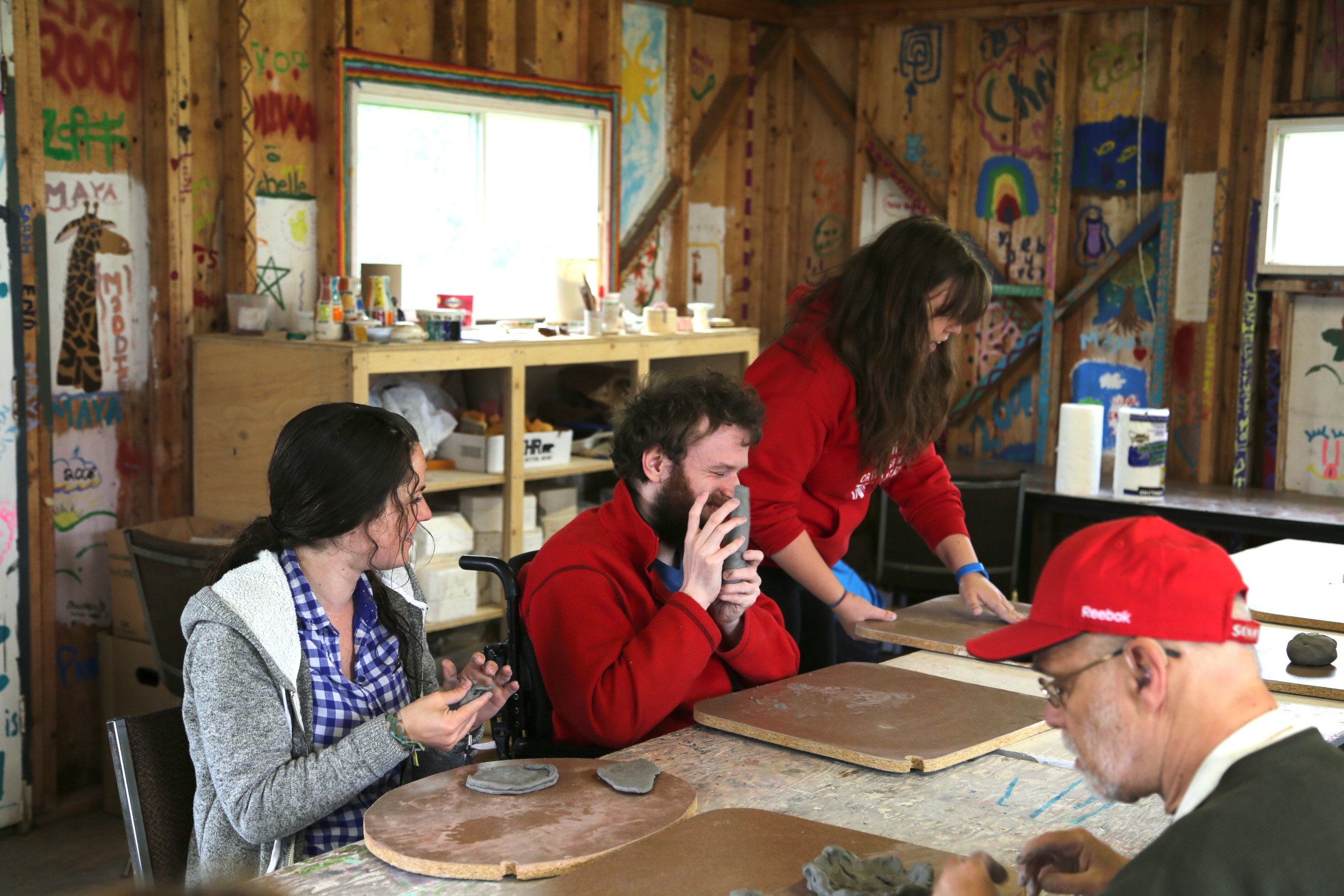 Staff and blind campers making things with clay.